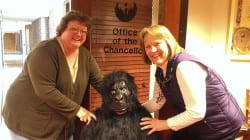     Chancellor's Office staff, Paula Marcec and Becky Ouradnik, pose with gorilla-suit-clad Emily Rogers