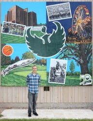 Beau Thomas stands by the Studio Arts Mural