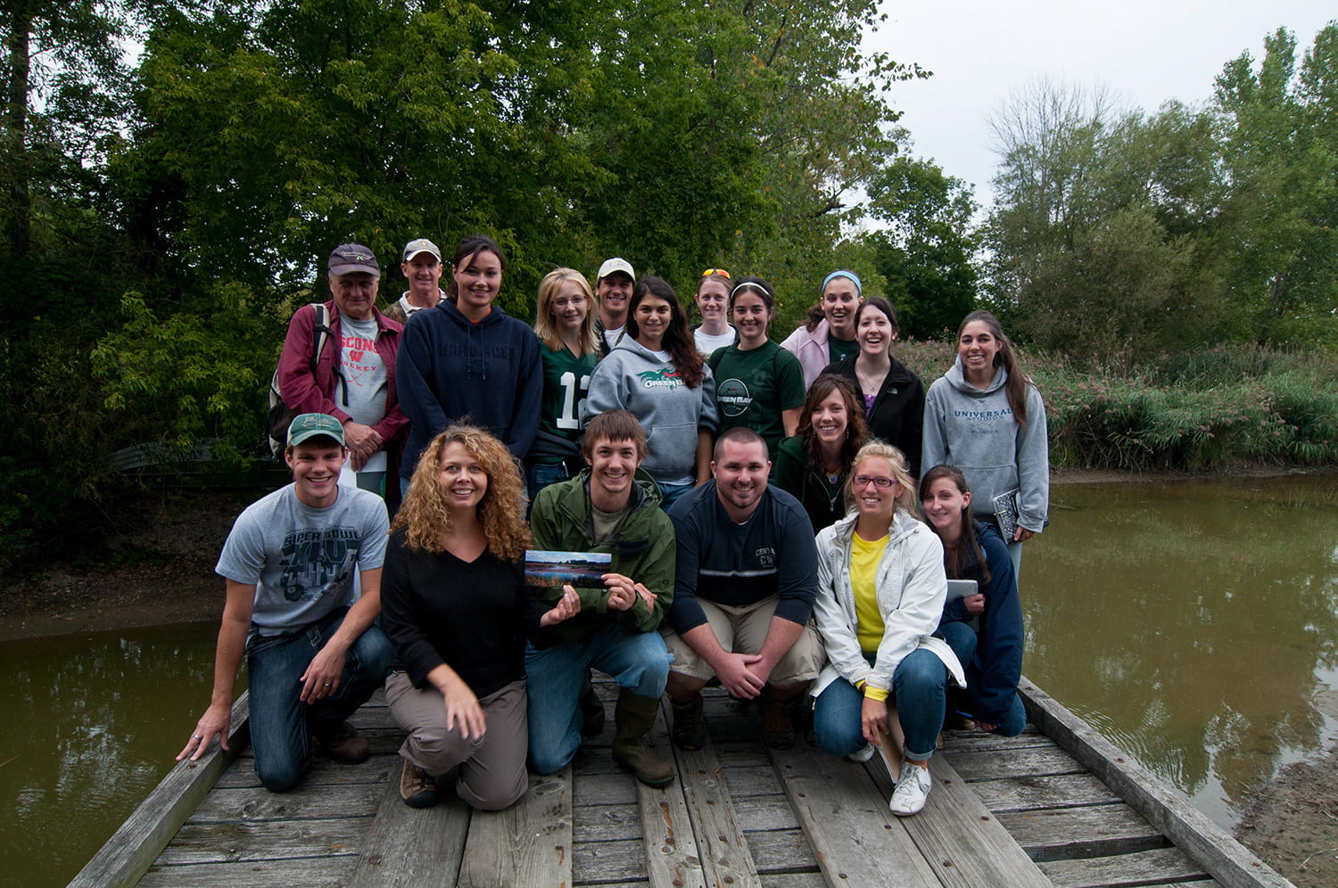 Amy Wolf posed with students by a waterway