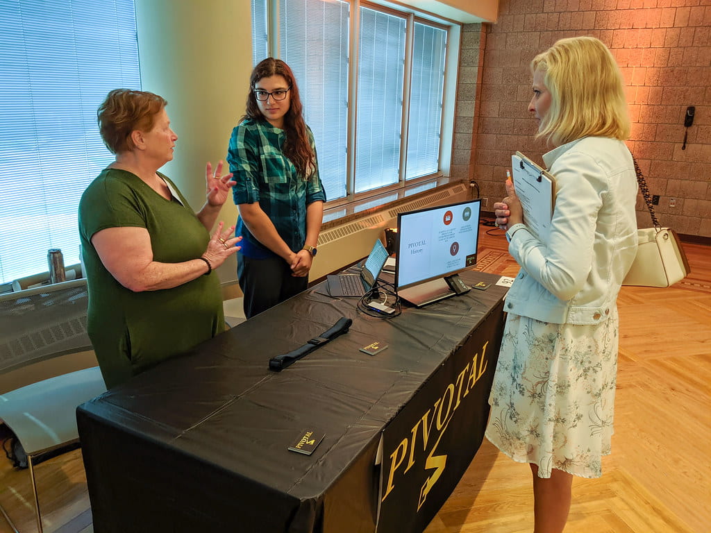 UW-Green Bay students Carol Brehmer, left, and Ebanie Schmidt explain their innovation “PIVOTAL”—a belt designed specifically for outdoor hobbyists and blue-collar workers—during the WiSys Innovation Showcase during WSTS at UW-Stout.