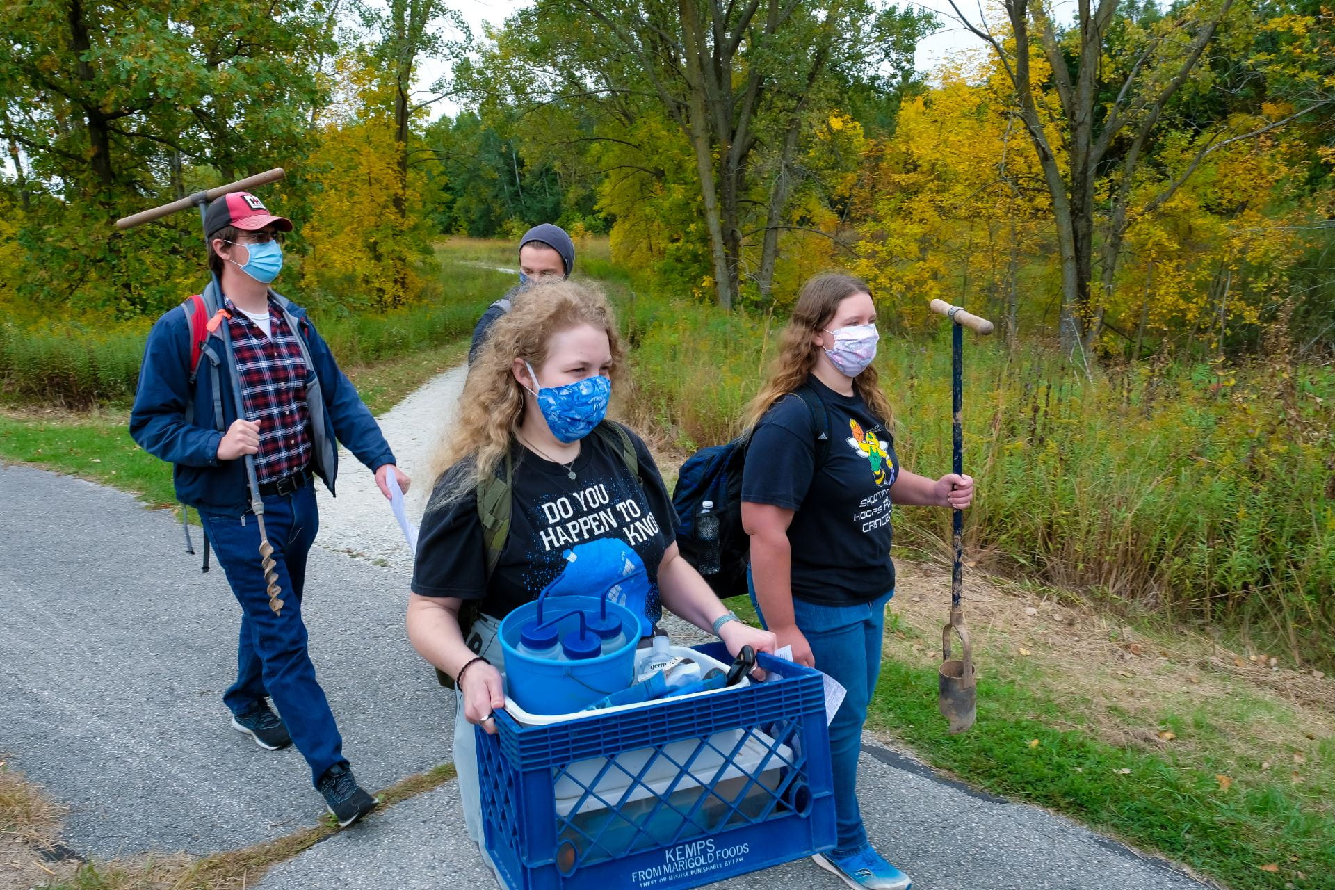 Photo of Assistant Professor Kelly Deuerling's Soil Environment students carrying soil augers and equipment for the soil testing outdoor lab in the Cofrin Memorial Arboretum on the UW-Green Bay campus.