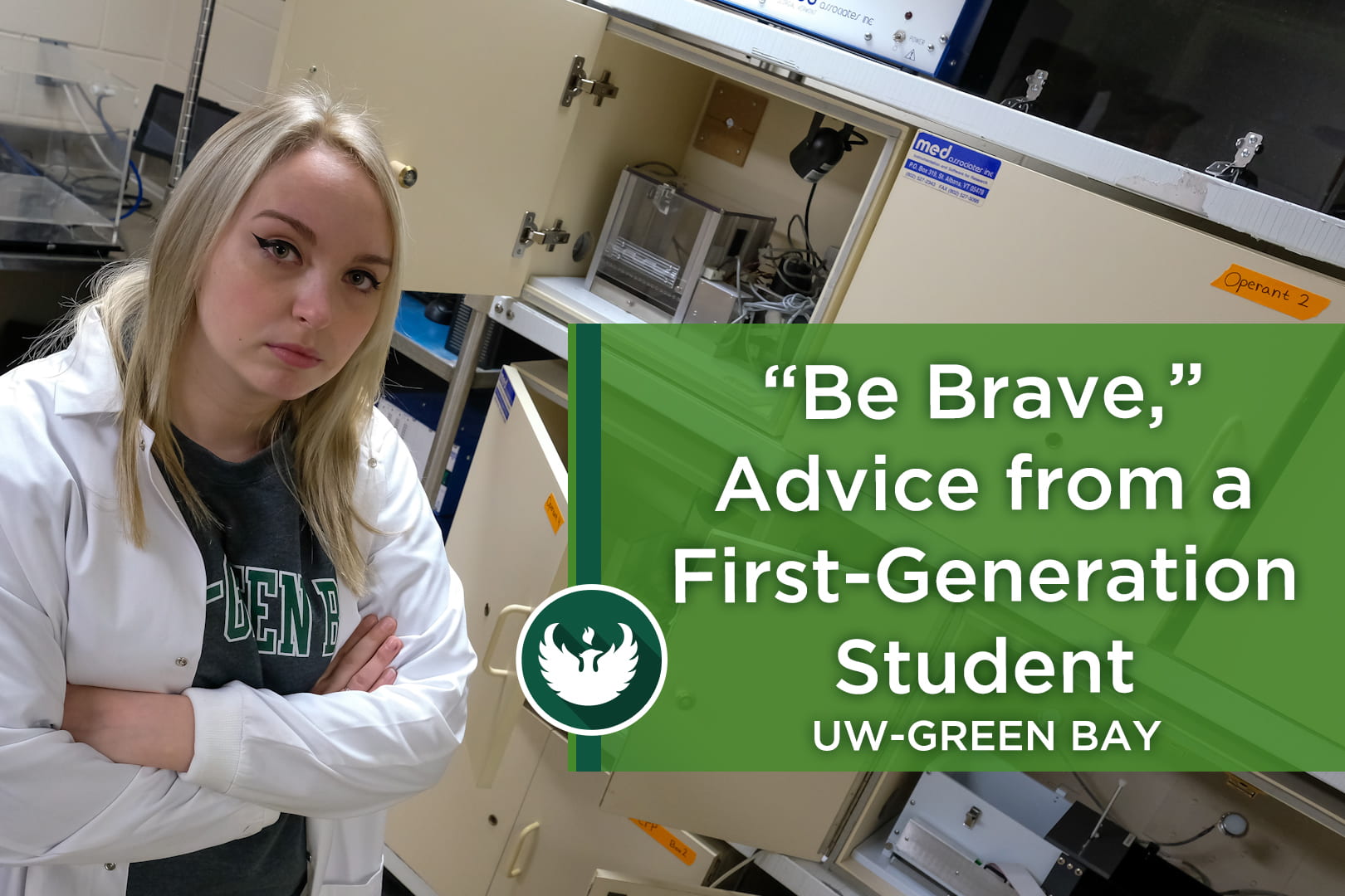Photo of UW-Green Bay’s Paige Anderson is a resilient first-generation psychology student, posing in the PANE Lab, wearing a white lab coat in front of the testing station.