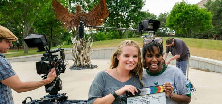From left, UW-Green Bay students Emily Reis and Soundarya Ritzman, pose with the video clapper board after the filming of UW-Green Bay's commercial PSA in front of the Phoenix sculpture at the UW-Green Bay, Green Bay Campus. Photo by Sue Pischke, University Photographer.