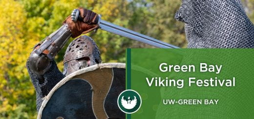 Photo of two men dressed as Vikings battling with swords during a Viking battle reenactment during the Viking Festival at UW-Green Bay.