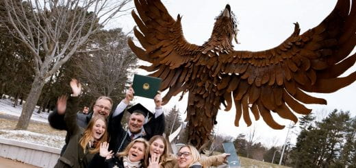 A graduate and his family cheer in front of the Phoenix statue after he graduated from the University of Wisconsin-Green Bay during the Fall/Winter Commencement on Saturday, December 18th, 2021.