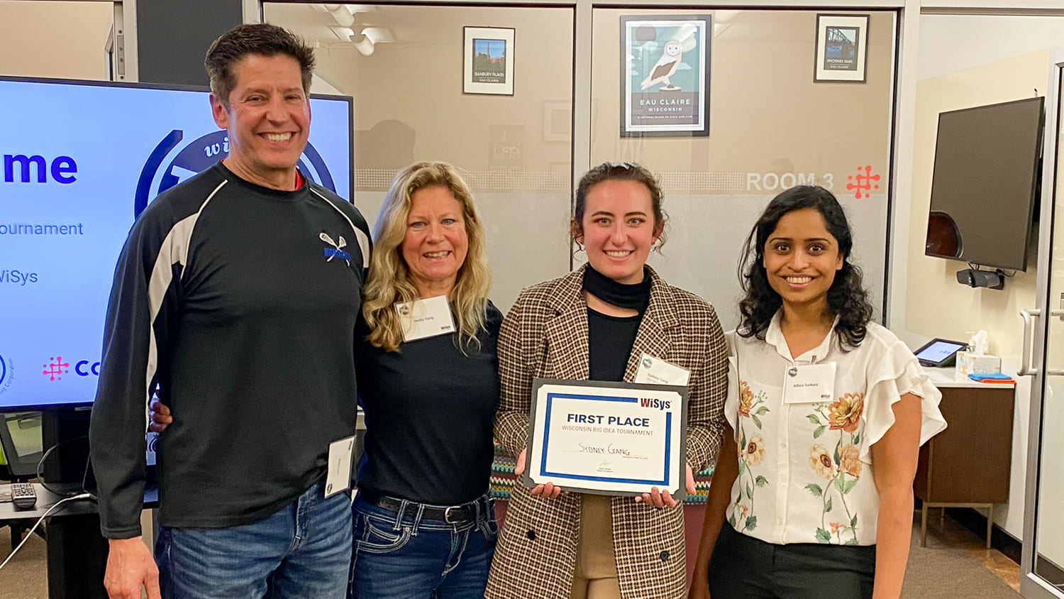 After winning the Wisconsin Big Idea Tournament, Sydney Gang holds up the first place certificate standing next to parents Jon and Becky Gang, left, and WiSys Assistant Director Adhira Sunkara, right.