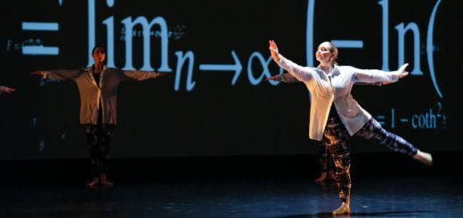 Theatre and Dance student performs ballet as she stretches her right arm and hand forward and turns on her right foot as large mathmatical equations projected on the University Theatre’s stage behind her during Dance Works 2023: A Concert of Dance on March 3, 2023.
