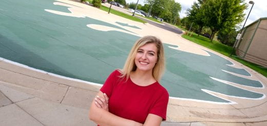 Kendra Lepper, a Communication major, stands in front of the giant painted Phoenix mural that covers the circle drive outside Mary Ann Cofrin Hall at UW-Green Bay, Green Bay campus on Sept. 6, 2022.