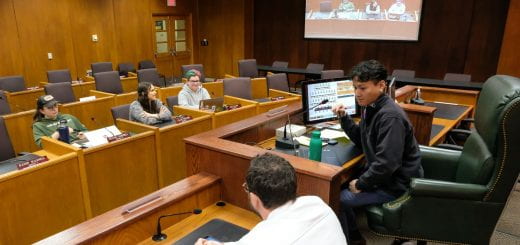 State and Local Government students pretend to be the mayor, city council members, and members of the public as they engage in a city council simulation about building a new city park inside the council chamber at Green Bay City Hall.